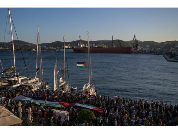 People gather at the port of Syros Island for the departure of two vessels, forming the Oxygen delegation to join the Global Sumud Flotilla, an international mission aiming to break the Israeli blockade of Gaza and to deliver humanitarian aid to Palestinians, on September 14, 2025. (Photo by Aris MESSINIS / AFP)