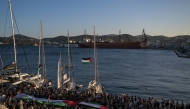 People gather at the port of Syros Island for the departure of two vessels, forming the Oxygen delegation to join the Global Sumud Flotilla, an international mission aiming to break the Israeli blockade of Gaza and to deliver humanitarian aid to Palestinians, on September 14, 2025. (Photo by Aris MESSINIS / AFP)
