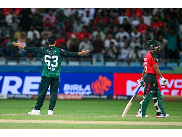 Pakistan's Saim Ayub (L) celebrates after dismissing Bangladesh's Nurul Hasan (R) during the Asia Cup 2025 Super Four Twenty20 international cricket match between Bangladesh and Pakistan at the Dubai International Stadium in Dubai on September 25, 2025. (Photo by Sajjad HUSSAIN / AFP)
