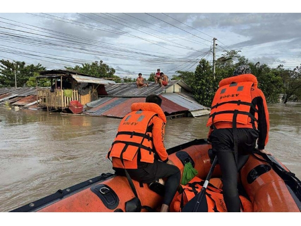 This handout photo taken on September 26, 2025 and released on September 27 by the Philippine Coast Guard shows coast guard personnel rescuing residents from their flooded house at the height of Severe Tropical Storm Bualoi, at a village in Ormoc City, Leyte province. (Photo by Handout / Philippine Coast Guard (PCG) / AFP)