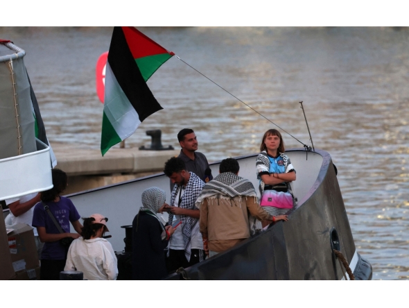 (Files) Swedish climate activist Greta Thunberg (R) is seen on board of a vessel of a civilian flotilla remains moored at Barcelona port on September 1, 2025. (Photo by Lluis Gene / AFP)
