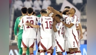 Qatar players gather on the pitch during the match against Oman.