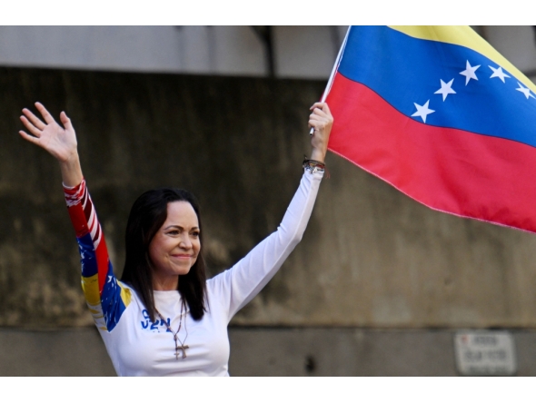 (Files) Venezuelan opposition leader Maria Corina Machado waves a national flag in Caracas on January 9, 2025. (Photo by Juan Barreto / AFP)