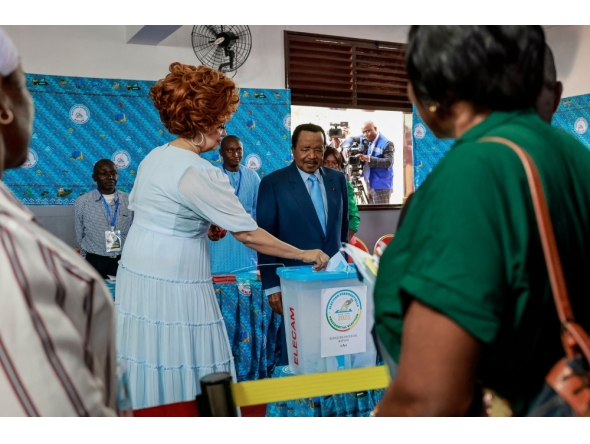 Paul Biya, President of Cameroon and presidential candidate for the Cameroon People's Democratic Movement (CPDM), watches as Cameroon First Lady Chantal Biya casts her ballot at a polling station in Yaounde on October 12, 2025 during Cameroon's presidential election. (Photo by Daniel Beloumou Olomo / AFP)