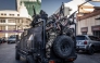 Members of Madagascar’s Army CAPSAT unit ride in armoured vehicles while assuming a defensive posture as they leave the Presidential Palace in Antananarivo, October 14, 2025. (Photo by Luis Tato / AFP)