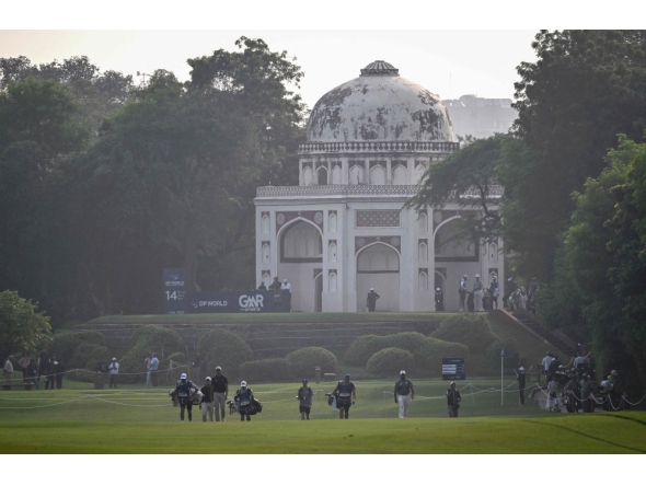 Participants walk on a golf course beside a Mughal-era heritage monument during the DP World India Championship 2025 golf tournament on October 17, 2025. (Photo by Arun Sankar / AFP)