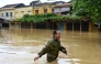 A man wades through a flooded street following heavy rains in Hoi An on October 30, 2025.  Photo by Nhac Nguyen / AFP