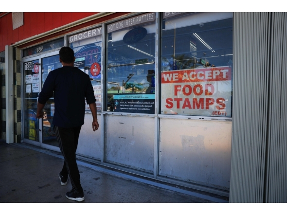 A 'We Accept Food Stamps' sign hangs in the window of a grocery store on October 31, 2025 in Miami, Florida. (Photo by Joe Raedle / Getty Images via AFP)