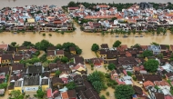 (Files) This aerial picture shows floodwaters inundating streets and buildings following heavy rains in Hoi An on October 30, 2025. (Photo by NHAC NGUYEN / AFP)