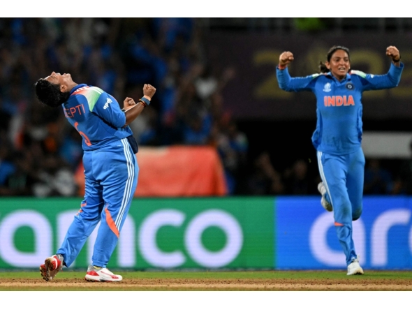 India's Deepti Sharma (left),  team captain Harmanpreet Kaur celebrate during the ICC Women's Cricket World Cup 2025 one-day international (ODI) final match between India and South Africa at the DY Patil Stadium in Navi Mumbai on November 2, 2025. (Photo by Punit Paranjpe / AFP)