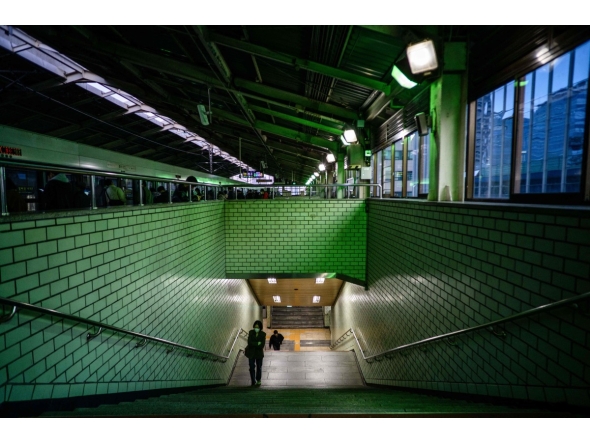 Commuters walk up a staircase towards a platform at a metro station in Seoul on November 4, 2025. (Photo by ANTHONY WALLACE / AFP)