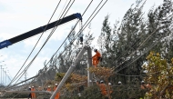 An electricity crew works on downed power lines to restore services in the aftermath of Typhoon Kalmaegi in Gia Lai province, central Vietnam on November 7, 2025. (Photo by Nhac Nguyen / AFP)