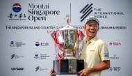 This handout photograph from the Asian Tour taken and received on November 9, 2025 shows Japan's Yosuke Asaji posing with the trophy after the 2025 Moutai Singapore Open golf tournament. (Photo by Graham Uden / Asian Tour / AFP) 