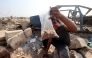 A Palestinian boy shows a bag of seeds and nuts he collected from the sand along the verge of a road near in the Nuseirat refugee camp in the central Gaza Strip, on November 9, 2025. (Photo by Eyad Baba / AFP)