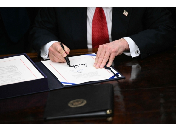 US President Donald Trump signs the bill package to re-open the federal government in the Oval Office of the White House in Washington, DC, on November 12, 2025. (Photo by Brendan Smialowski / AFP)