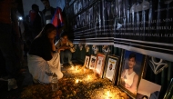 Family members of those killed in September anti-corruption protests take part in a candlelight vigil in front of the fire-damaged parliament building in Kathmandu on November 9, 2025. (Photo by Prakash Mathema / AFP)
