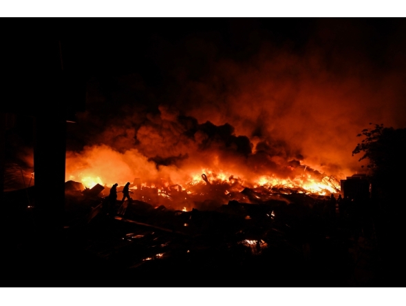 Firefighters work to extinguish a fire after an explosion in an industrial area of Ezeiza, Buenos Aires province, Argentina on November 15, 2025. Powerful explosions rocked an industrial area and ignited a fire south of Buenos Aires on the night of November 14, 2025, officials said, with at least 22 people sent to the hospital. (Photo by Luis Robayo / AFP