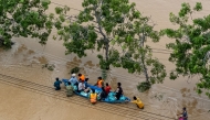 This aerial photo shows people wading through floodwaters in Phan Rang in southern Vietnam's Khanh Hoa province on November 21, 2025. (Photo by Bao Quan / AFP)