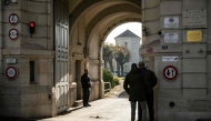 A member of the prison staff stands behind the entrance door of the jail of Dijon central eastern France on November 27, 2025. (Photo by Arnaud Finistre / AFP)