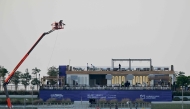 Workers prepare a stand at the Lusail International Circuit ahead of the Formula One Qatar Grand Prix in Lusail on November 27, 2025. (Photo by Mahmud Hams / AFP)