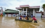 People ride a boat across a flooded street in Ambatale on the outskirts of Colombo on November 29, 2025. (Photo by Ishara S. KODIKARA / AFP)