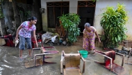 Residents salvage their belongings at an inundated house following flash floods in the aftermath of Cyclone Ditwah, in Wellampitiya on the outskirts of Colombo on December 3, 2025. (Photo by Ishara S. Kodikara / AFP)