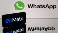 This photograph taken on January 12, 2023 in Toulouse, southwestern France shows a smartphone and a computer screen displaying the logos of WhatsApp app and its parent company Meta. Photo by Lionel BONAVENTURE / AFP