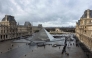 (Files) This photograph shows visitors, seen from the Sully wing, queuing in the Cour Napoleon by the pyramid, to enter the Louvre Museum in Paris on November 19, 2025. (Photo by Sébastien Dupuy / AFP)