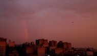 A general view of a rainbow at sunset following several days of rain in the Iranian capital Tehran on December 10, 2025. (Photo by Atta Kenare / AFP)