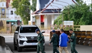 Cambodian police officials walk at the closed Poipet International border checkpoint between Cambodia and Thailand in Poipet, Banteay Meanchey province on December 12, 2025, amid clashes along the Cambodia-Thailand border. (Photo by Tang Chhin Sothy / AFP)