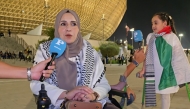 A Palestinian woman and child injured during the Gaza war speak during the Palestine-Saudi Arabia match of the FIFA Arab Cup Qatar at Lusail Stadium on Thursday. 