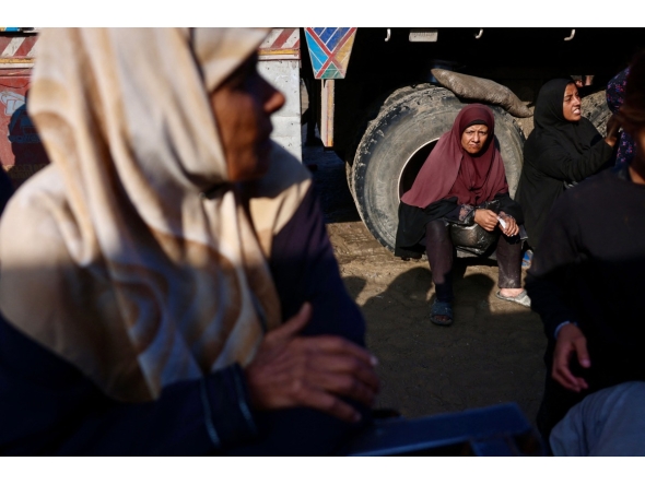 Displaced Palestinians wait to receive donated food portions at a charity kitchen in Khan Yunis in the southern Gaza Strip on December 17, 2025. (Photo by Bashar Taleb / AFP)
