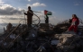 Children pose for photos taken by their parents on the rubble of a house demolished by Israeli authorities in the Palestinian village of Bizariya, in the Israeli-occupied West Bank, on December 24, 2025. (Photo by Zain JAAFAR / AFP)
