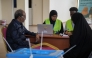 Electoral officials assist a voter at a polling station during local council elections in Mogadishu on December 25, 2025. (Photo by Hassan Ali ELMI / AFP)