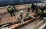 Museum employees install antique wooden planks from King Khufu’s second boat onto a metal structure at the Grand Egyptian Museum in Giza, on the outskirts of Cairo, on December 23, 2025. Photo by Ahmed Hasan / AFP