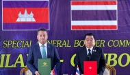 This handout photo released by Agence Kampuchea Press (AKP) on December 27, 2025 shows Cambodia's defence minister Tea Seiha (L) and Thailand's defence minister Nattaphon Narkphanit (R) posing with documents during the special General Border Committee (GBC) meeting at a border checkpoint in Thailand's Chanthaburi province. Photo by Agence Kampuchea Presse (AKP) / Agence Kampuchea Press (AKP) / AFP