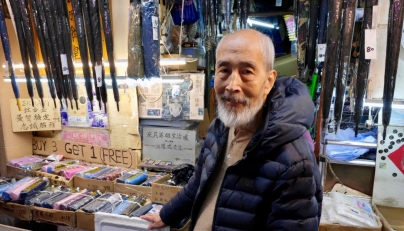 Yau Yiu-wai, 73, one of the few remaining umbrella repairmen in Hong Kong, poses poses for a photo in Hong Kong's Sham Shui Po district on December 26, 2025. Photo by Tommy WANG / AFP