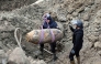 This handout photograph taken on December 28, 2025 and released by Serbia's Ministry of Interior, shows Serbian bomb disposal experts removing a 470-kg World War II aerial bomb, dropped on Nazi-occupied Belgrade in 1944, from a construction site in the Serbian capital. (Photo by Handout / Serbian Ministry of Interior Affairs / AFP) 