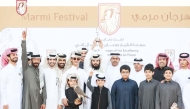 Falconers and participants after winning a competition on the first day of the festival.   