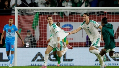 Algeria's forward #27 Adil Boulbina (C) celebrates scoring his team's first goal with Algeria's defender #5 Zineddine Belaid the Africa Cup of Nations (CAN) round of 16 football match between Algeria and Democratic Republic of Congo at the Prince Moulay El Hassan stadium in Rabat on January 6, 2026. (Photo by Abdel Majid BZIOUAT / AFP)