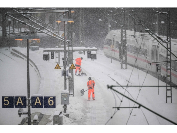 Workers clear the snow from the platforms at Hamburg main railway station in Hamburg, Germany, on January 9, 2026 (Photo by DANIEL REINHARDT / AFP)