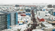 This aerial view taken by Mads Schmidt Rasmussen and handed out by Arctic Creative shows people as they take part in a demonstration to protest against the US President's plans to take Greenland, on January 17, 2026 in Nuuk, Greenland. (Photo by Mads Schmidt Rasmussen / various sources / AFP) 
