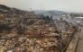 Aerial view of the charred remains of destroyed homes after a wildfire in Concepcion, Chile, on January 18, 2026. Chilean President Gabriel Boric declared a state of emergency on January 18 for two southern regions where raging wildfires have forced about 20,000 people to evacuate their homes. (Photo by Raul Bravo / AFP)

