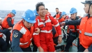 This handout from the Chinese Coast Guard taken and released by the Chinese embassy in Manila on January 23, 2026 shows Chinese Coast Guard personnel assisting a rescued Filipino crew member of a capsized cargo ship near the contested Scarborough Shoal in the South China Sea. Photo by Handout / various sources / AFP