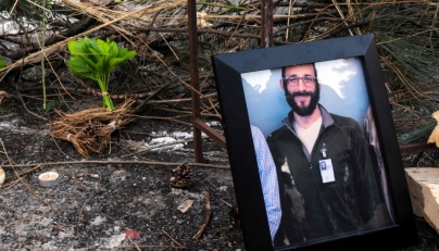 A photograph of 37-year-old Alex Pretti can be seen at a makeshift memorial in the area where he was shot dead by federal immigration agents earlier in the day in Minneapolis, Minnesota, on January 24, 2026. (Photo by Roberto Schmidt / AFP)