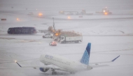 An Embraer 175 of United airlines taxies to take off as the snow falls on the tarmac of LaGuardia airport in New York on January 25, 2026. Photo by CHARLY TRIBALLEAU / AFP