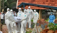 Representational file photo. Doctors and relatives wearing protective gear dig a grave to bury a victim of the brain-damaging Nipah virus in Kozhikode, Kerala, India, May 24, 2018. Reuters/Stringer