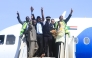 Sudan Airways members of staff celebrate as they stand at the door of the first domestic flight arriving from Port Sudan, after it landed at Khartoum International Airport following a three-year hiatus, on February 1, 2026. (Photo by Ebrahim Hamid / AFP)