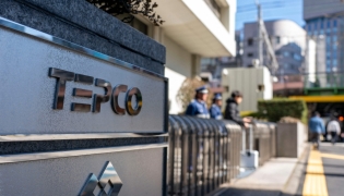 The logo of Tokyo Electric Power Company is seen at an entrance to the company's headquarters in Tokyo on February 9, 2026. (Photo by Kazuhiro NOGI / AFP)
