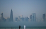 People look at the skyline covered in fog in Doha on February 9, 2026. (Photo by Mahmud HAMS / AFP)
